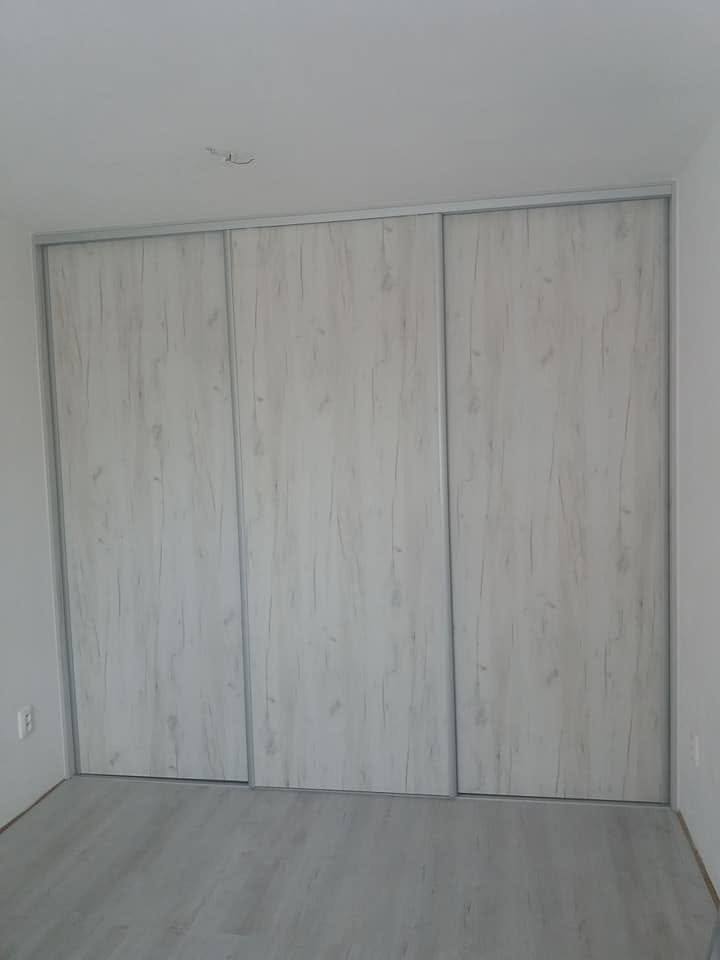 Kasten mit drei Türen in hellem Holzdekor im leeren Zimmer.