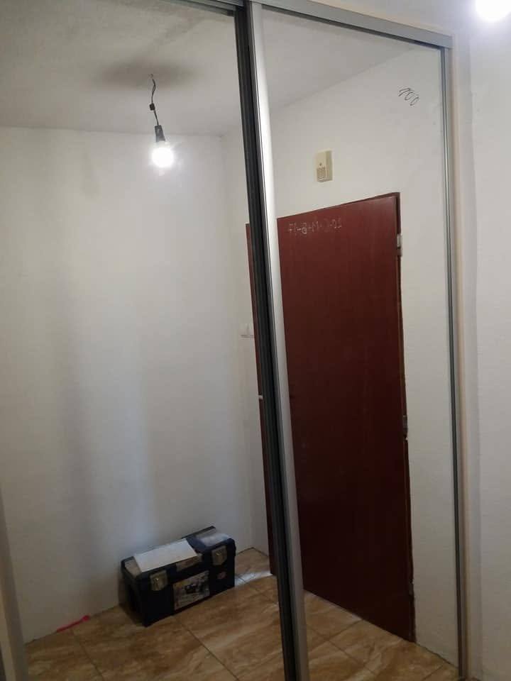 Kasten mit Tür in dunklerem Holzdekor an der Wohnungstür.