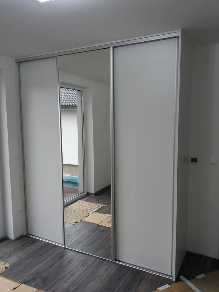 Einbaukasten mit verspiegelter und weißer Schiebetür.