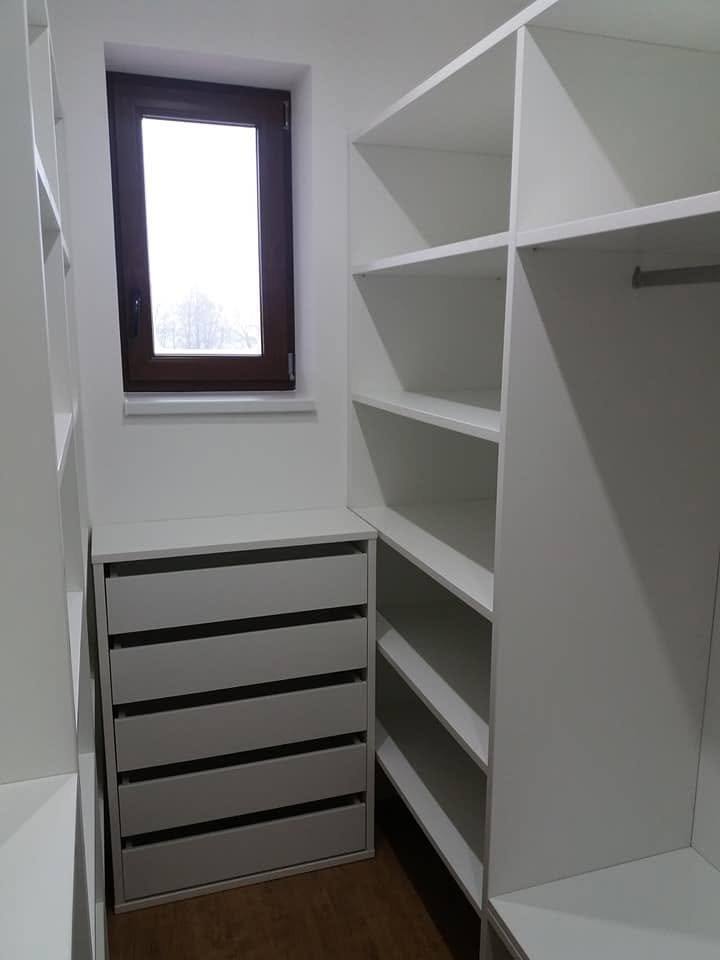 Weiße Böden und graue Laden neben dem kleinen Fenster.