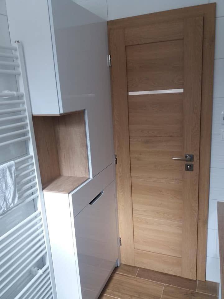Hoher weißer Badschrank mit offener Eichennische beim Heizkörper