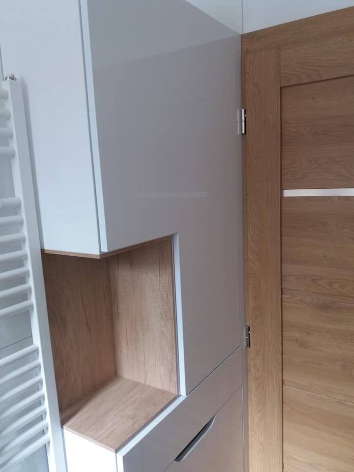 Weißer Badschrank mit Eichennische neben der Eichentür