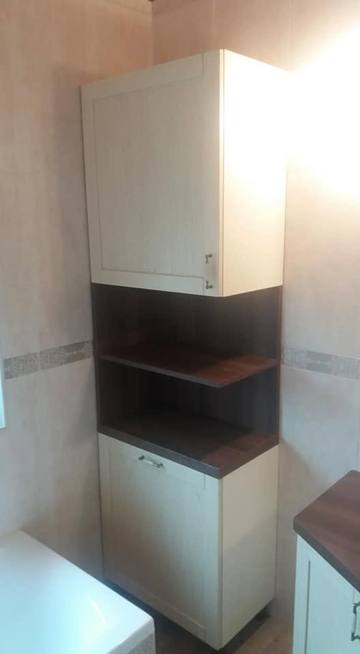 Hoher Badschrank mit cremefarbenen Türen und dunkler Nische
