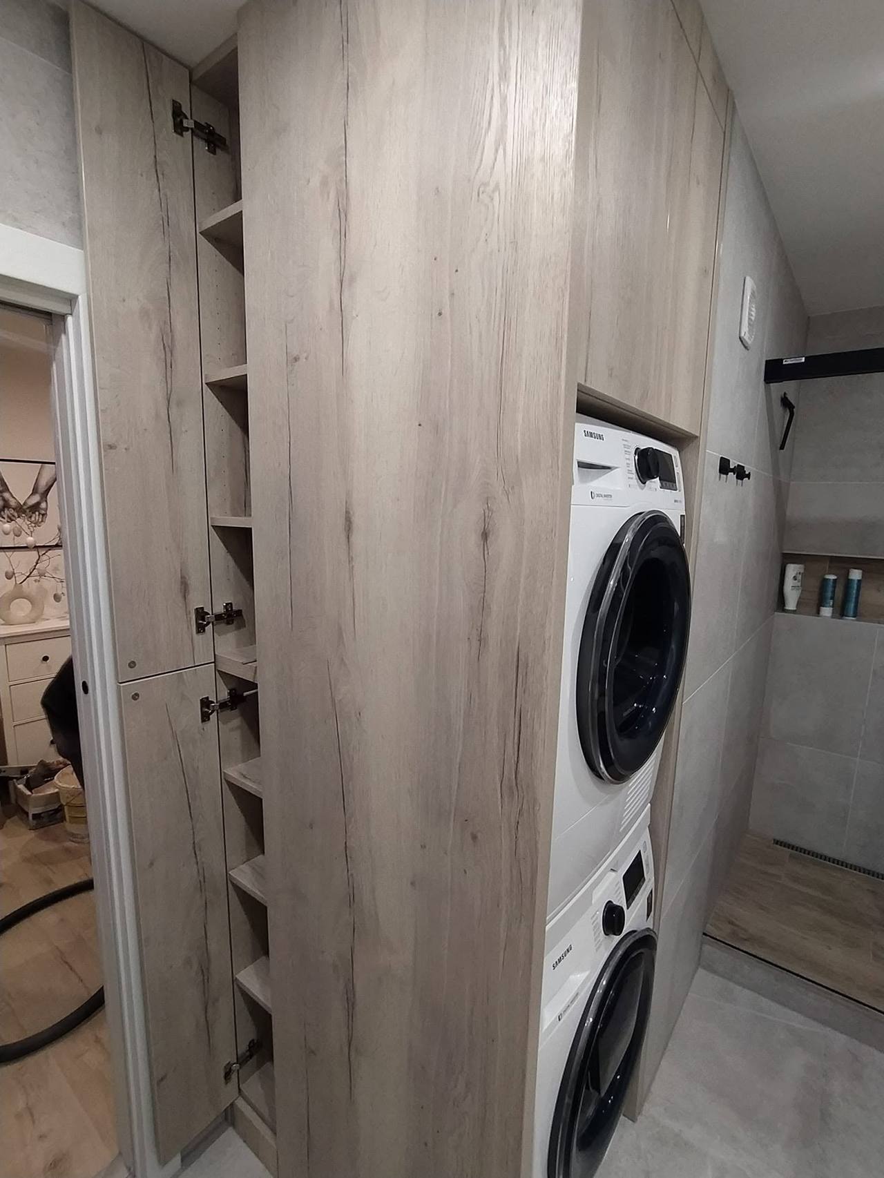 Hoher Schrank mit Waschturm und offenen Regalen daneben