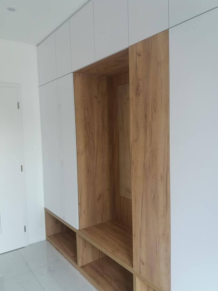 Hohe Garderobennische in Eichendekor mit offenem Fach im unteren Teil.