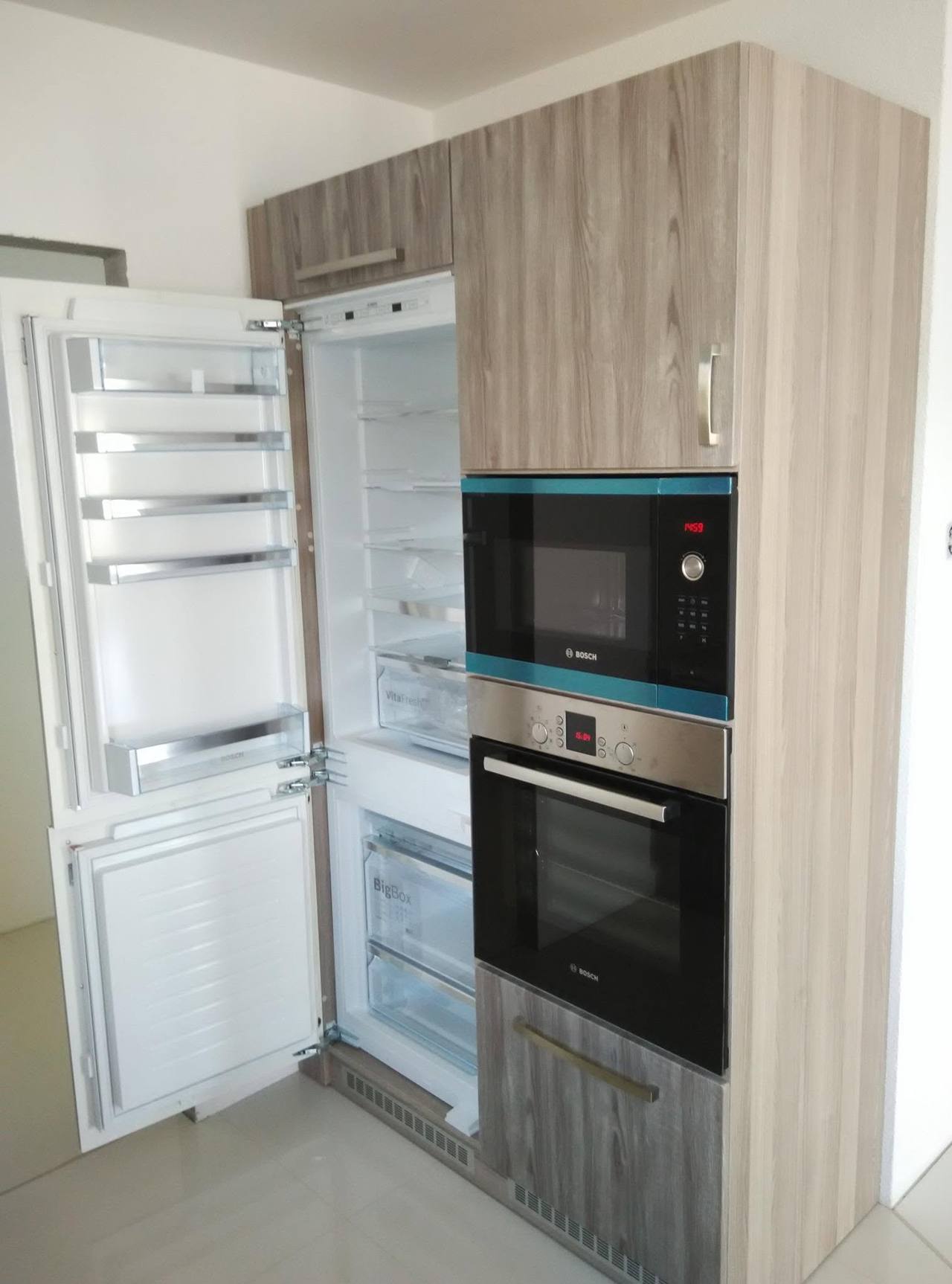 Geöffneter Einbaukühlschrank im Hochkastenblock in grauer Eiche