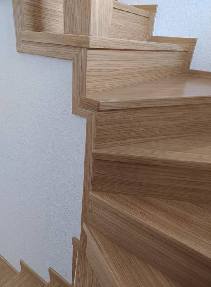Detail masívnych dubových stupňov točitého schodiska zhora