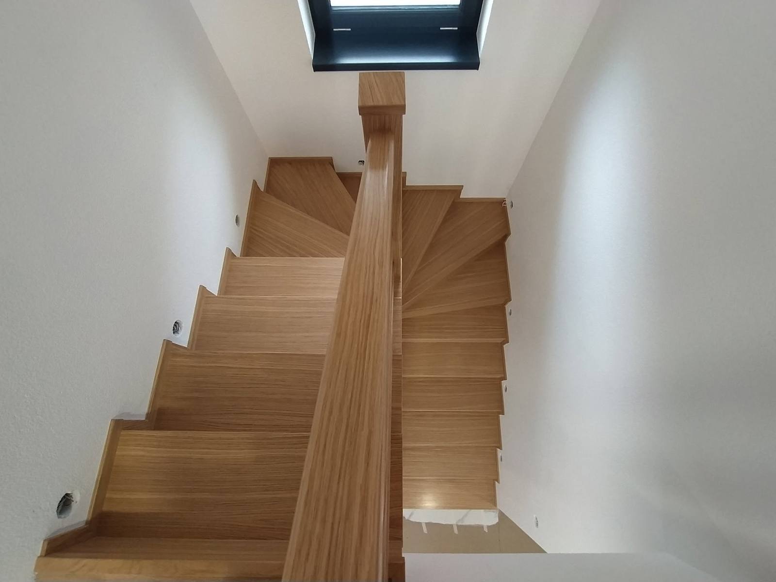 Verwinkelte Eichenstiege um den Mittelpfosten unter dem Dachfenster von oben
