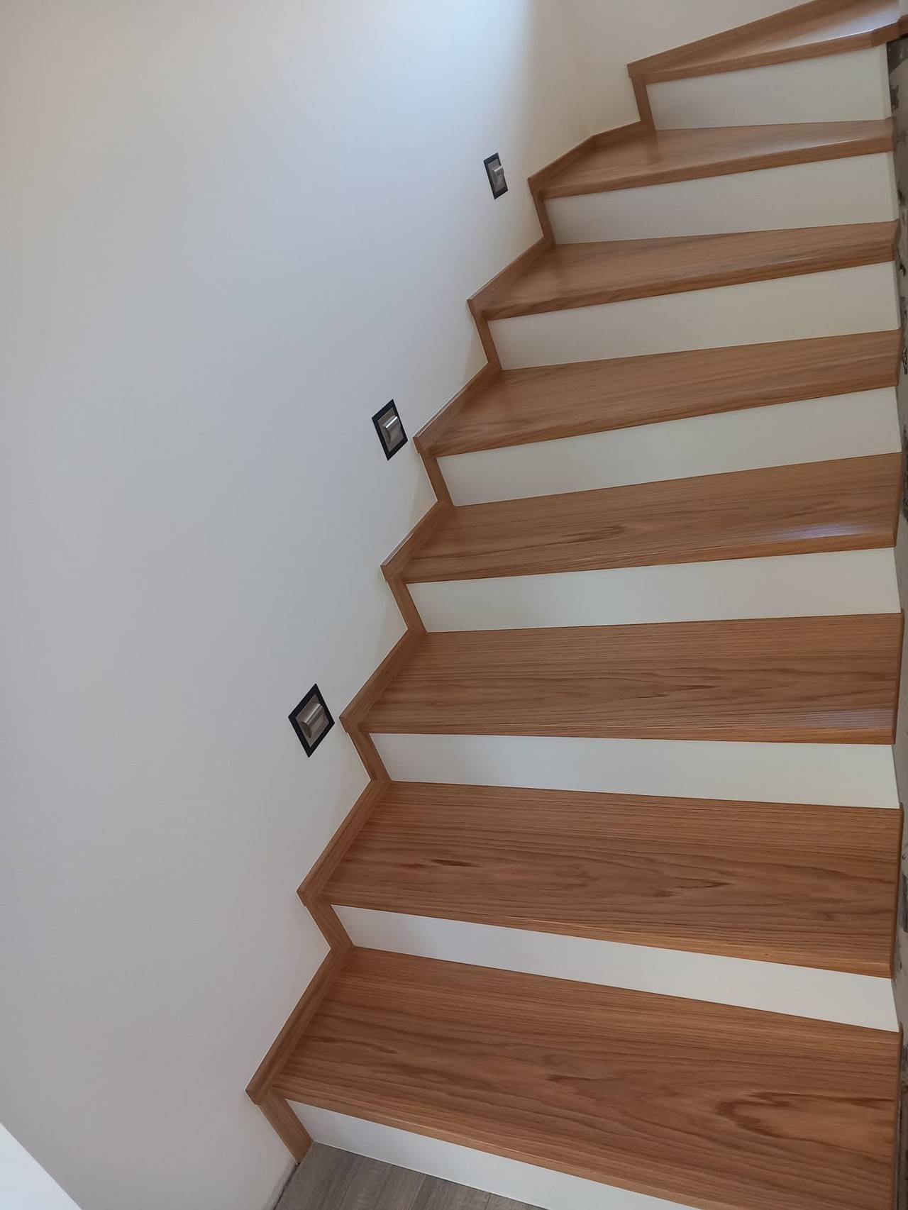 Eichenstufen mit weißen Setzstufen entlang der Wand