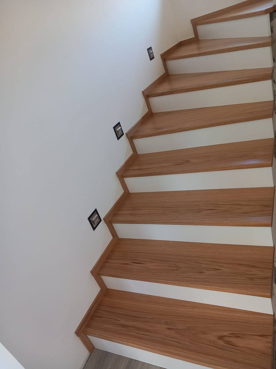 Eichenstufen mit weißen Setzstufen entlang der Wand