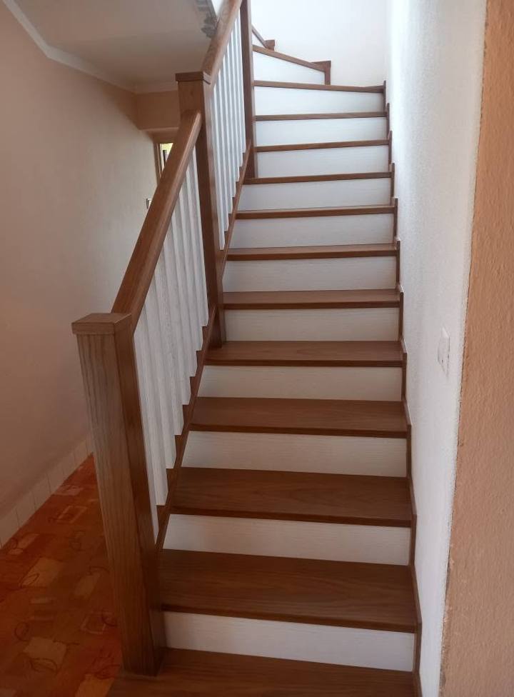 Unterer Teil der gewinkelten Stiege mit hellem Boden