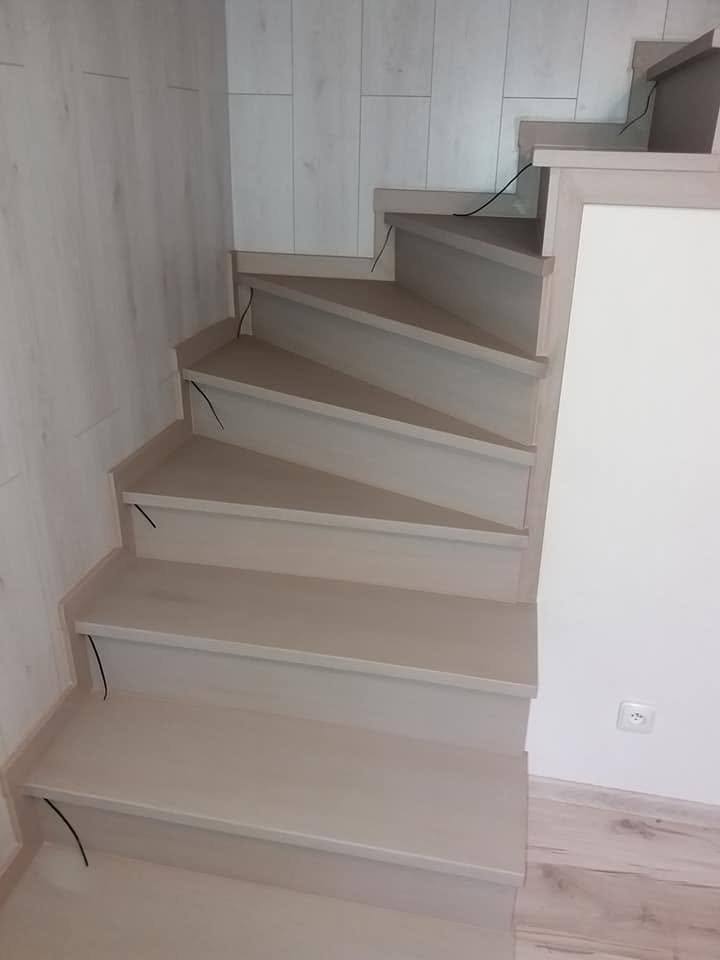 Gewinkelte Stiege mit Glas an heller Wand