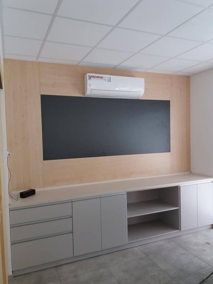 Büro-Wand mit Tafel auf Holzdekor-Paneel und grauem Schrank
