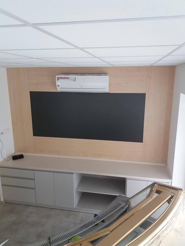 Wand im Besprechungsraum mit Holzdekor-Paneel, Tafel und niedrigem Schrank