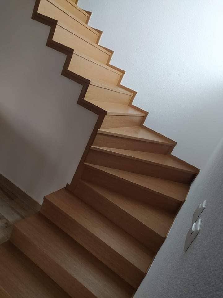 Gewendelte Eichenstiege an der weißen Wand von oben gesehen