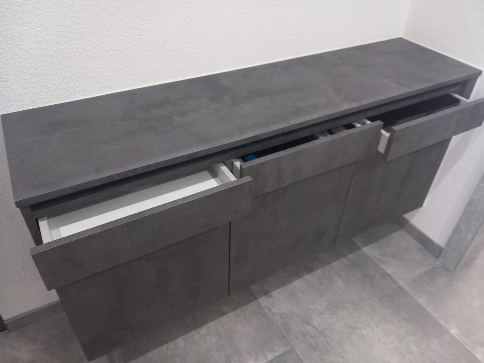 Anthrazitfarbene Kommode mit offenen Laden in Betonoptik