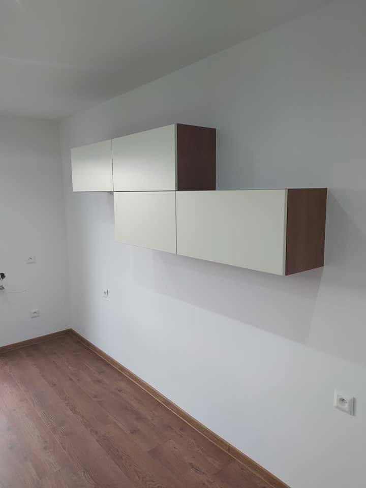 Zwei weiße Hängekästen mit Seiten in Nuss an leerer Wand
