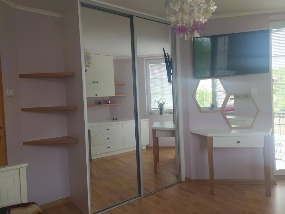 Verspiegelter Einbaukasten mit offenen Seitenregalen im hellen Zimmer.