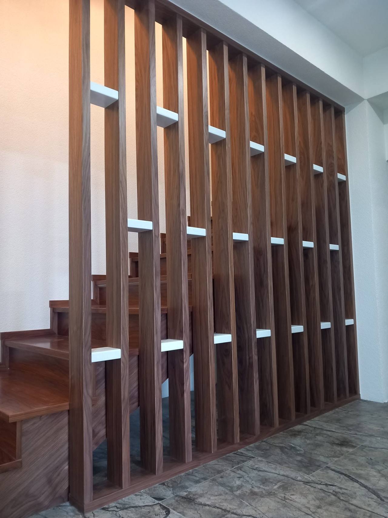 Dunkle Eichenlamellenwand entlang der Stiege aus anderem Winkel